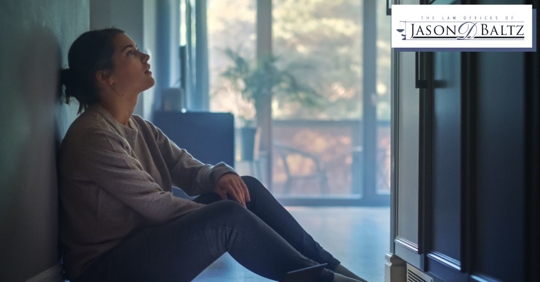 Woman stressed sitting against wall in a house